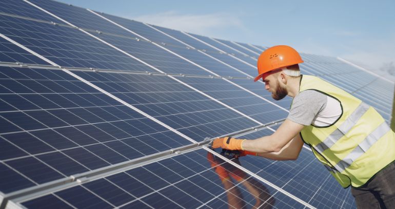 Fachkraft montiert eine Photovoltaikanlage